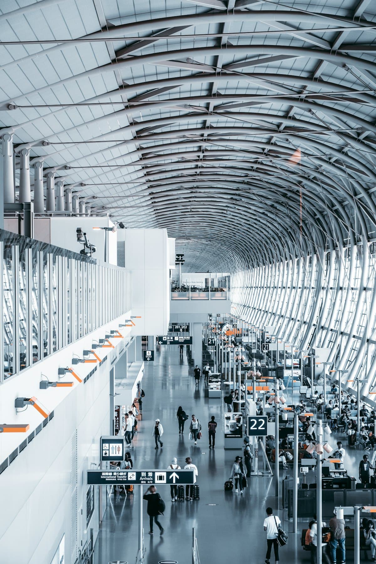 Travellers walking through a bright airport terminal