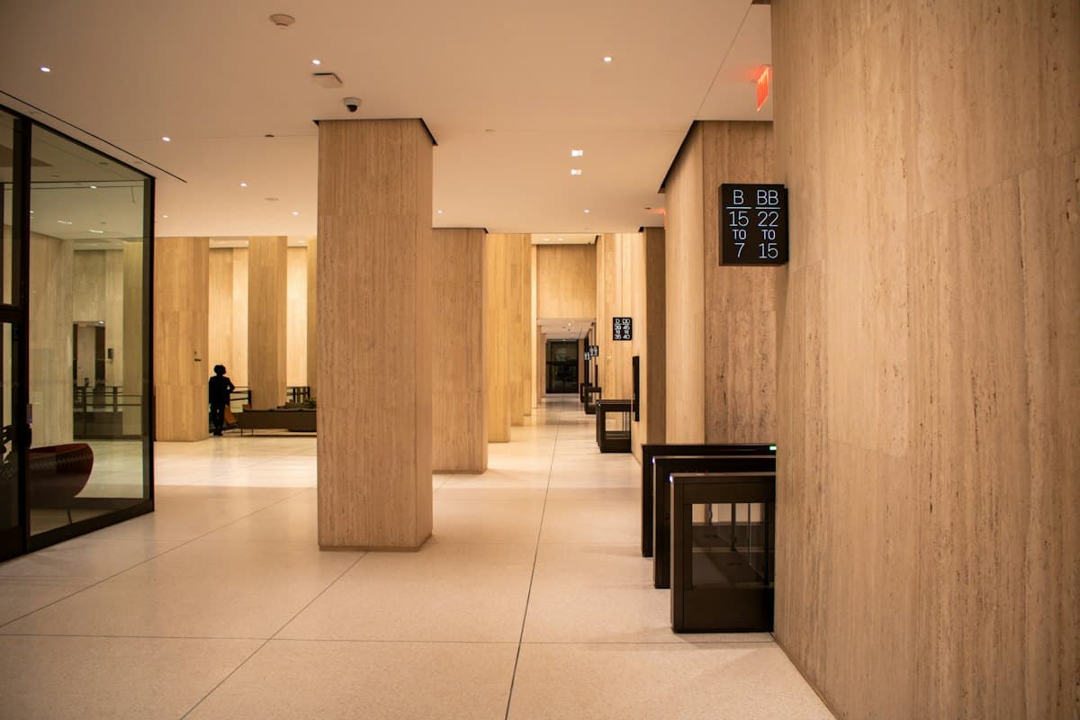 A modern building lobby with pillars and a security gate