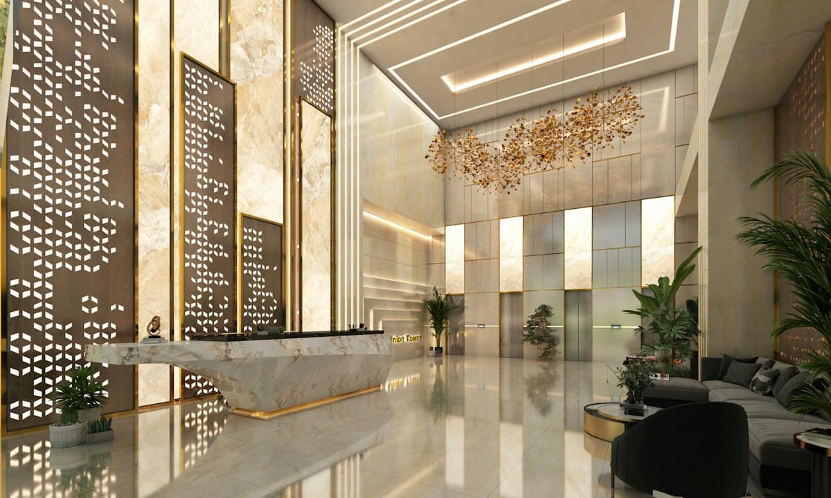 A modern office lobby with a marble reception desk and elevators